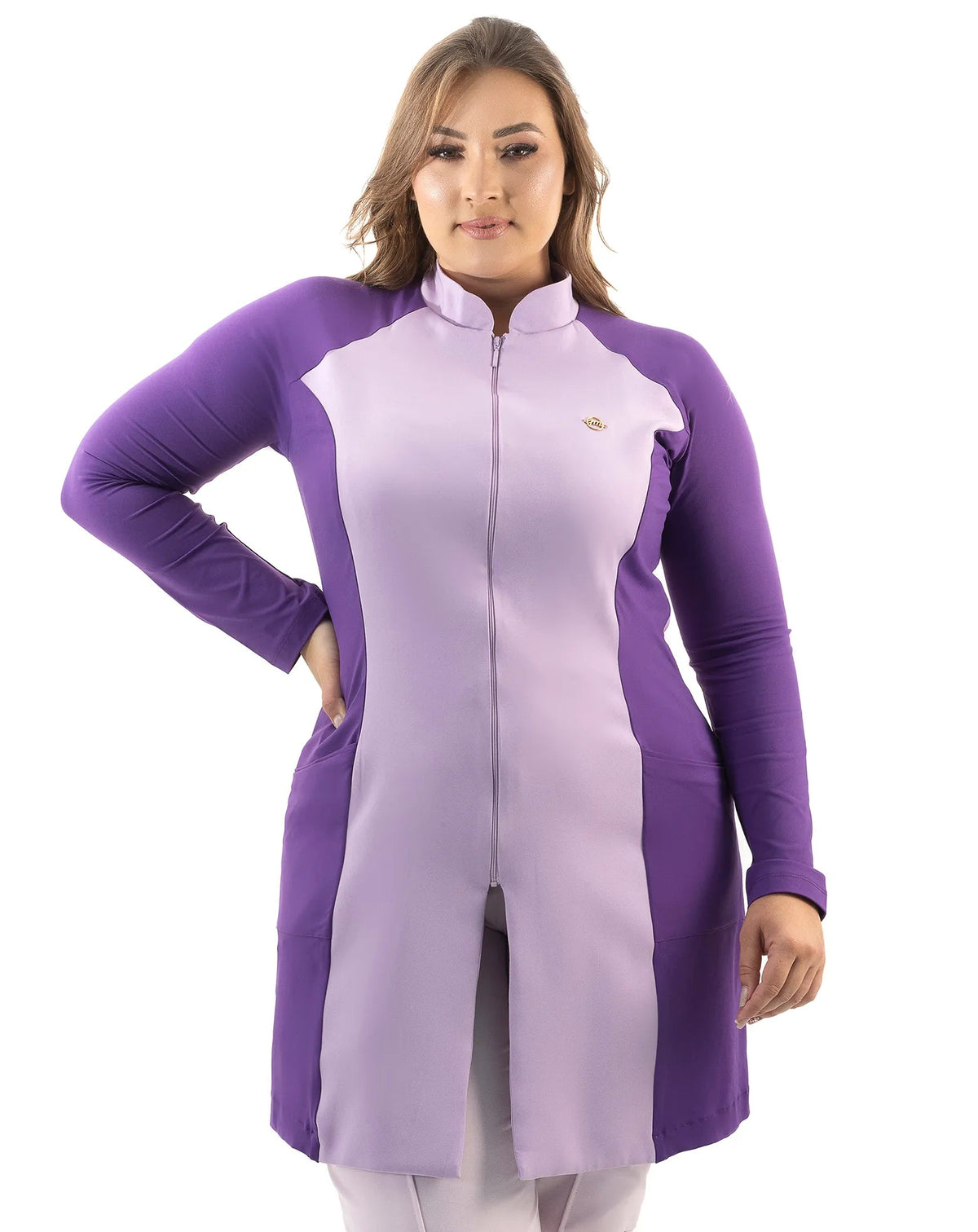 Jaleco feminino Vicky lavanda com roxo em modelo plus size de frente, com a mão na cintura e zíper frontal — foto 5