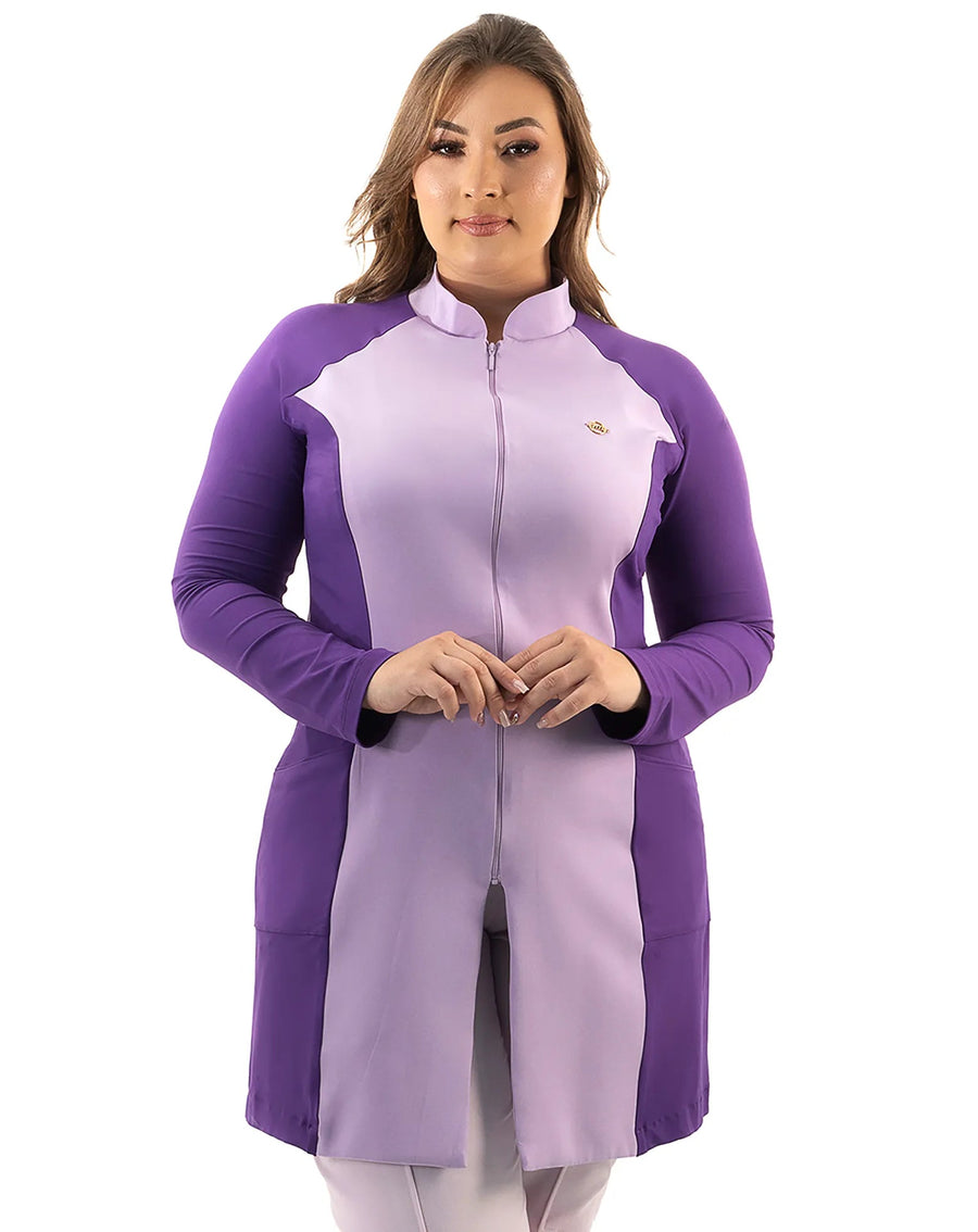 Jaleco feminino Vicky lavanda com roxo de frente em modelo plus size, mostrando gola alta, zíper e pin dourado