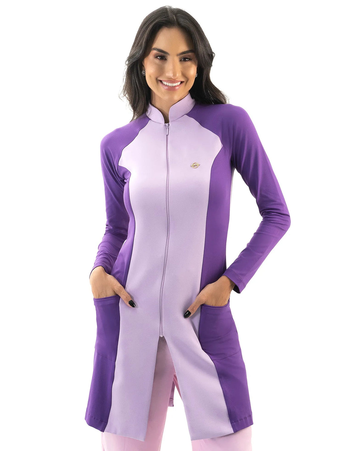 Jaleco feminino Vicky lavanda com roxo de frente, gola alta com zíper e mãos da modelo nos bolsos frontais — foto 2