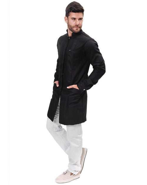 Jaleco masculino Man Simple Color preto visto de lado no modelo, corpo inteiro com mãos nos bolsos frontais