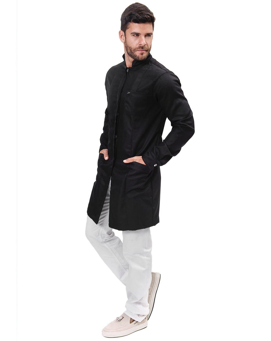 Jaleco masculino Man Simple Color preto visto de lado no modelo, corpo inteiro com mãos nos bolsos frontais