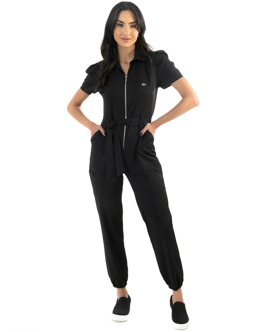 Macacão feminino Larissa preto de corpo inteiro, modelo com as mãos nos bolsos e gola tipo camisa com zíper