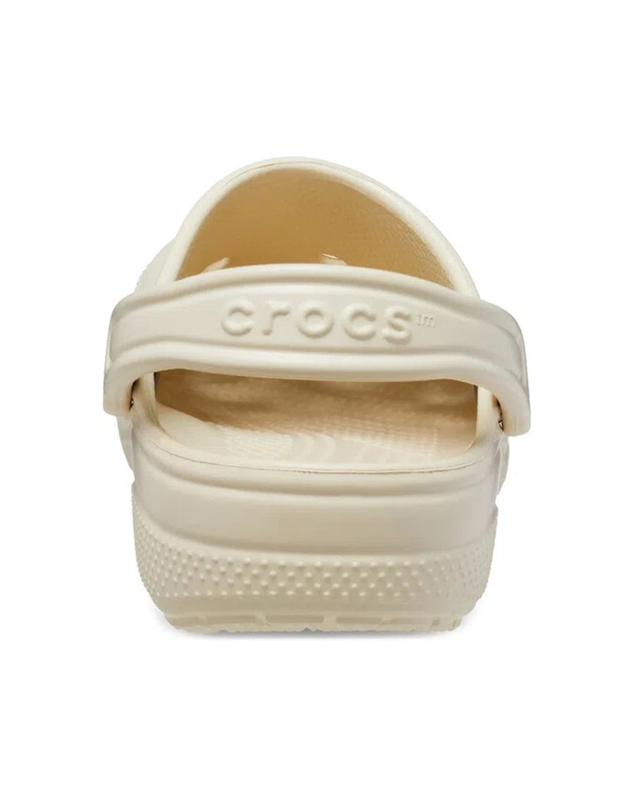 Sandália Crocs Classic Clog Bone bege vista de trás com a tira traseira em relevo Crocs e calcanhar texturizado