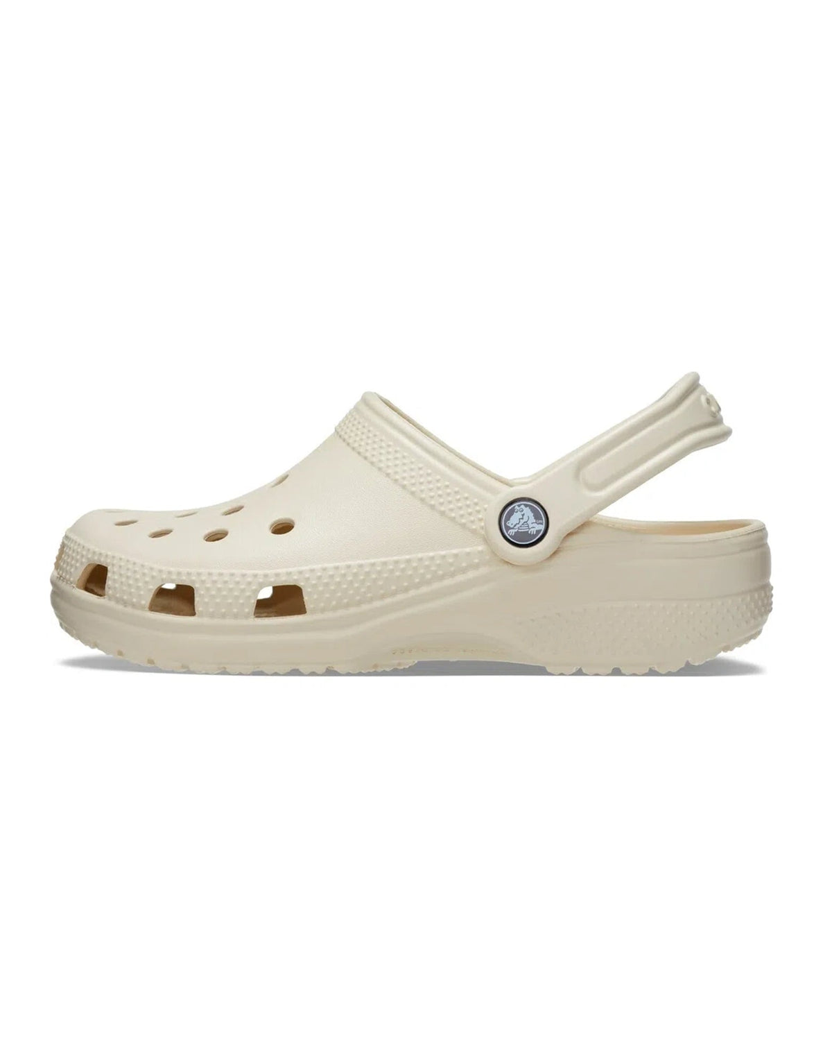 Sandália Crocs Classic Clog Bone bege vista da lateral interna com aberturas de ventilação e tira traseira levantada — foto 4