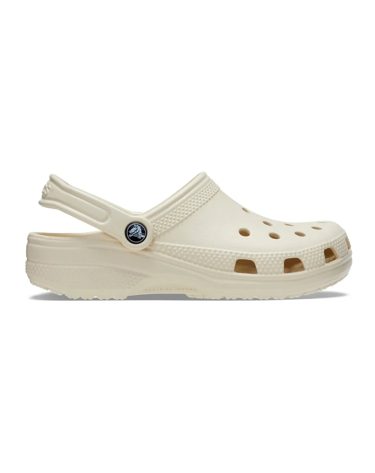 Sandália Crocs Classic Clog Bone bege em vista lateral com furos de ventilação e tira traseira com pino do logo