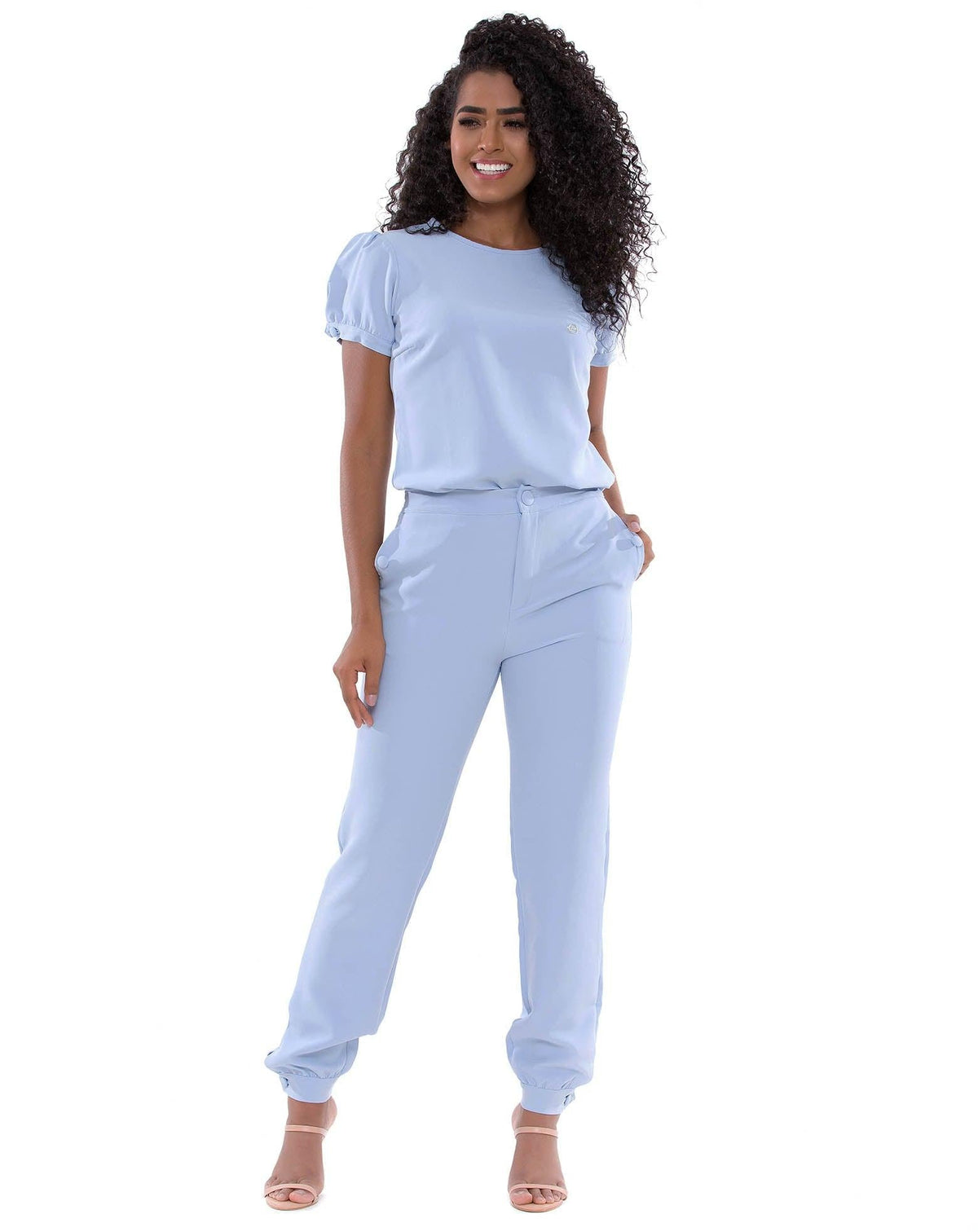 Scrub Feminino Antonella Azul Céu em vista frontal, com mão no bolso da calça jogger de punho ajustado — foto 3
