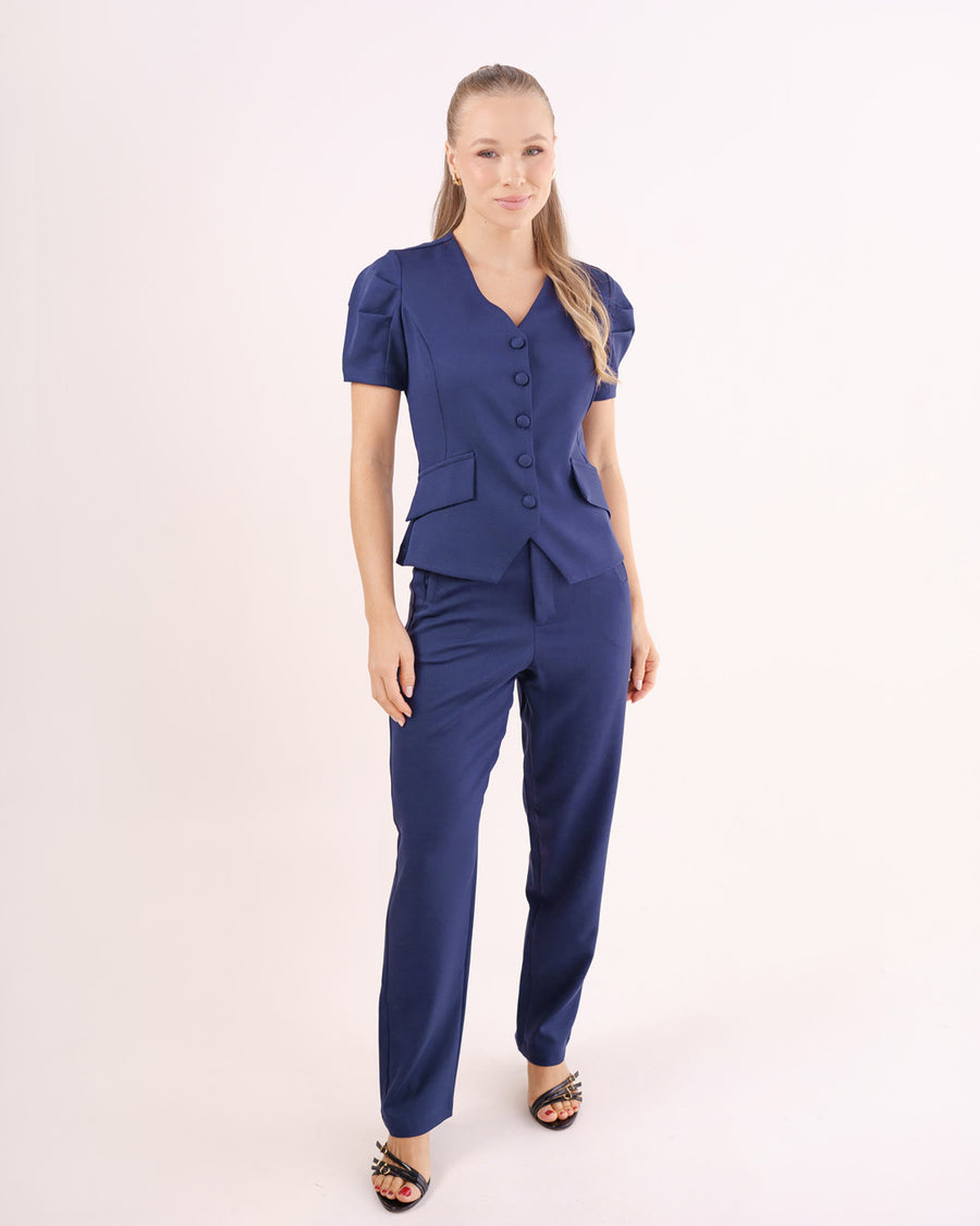 Scrub feminino Classic azul marinho de corpo inteiro em fundo branco, blusa acinturada de botões e calça reta