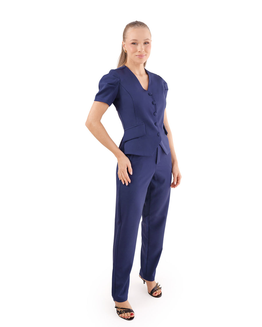 Scrub feminino Classic azul marinho em vista lateral de corpo inteiro, blusa de botões com bolsos e calça reta