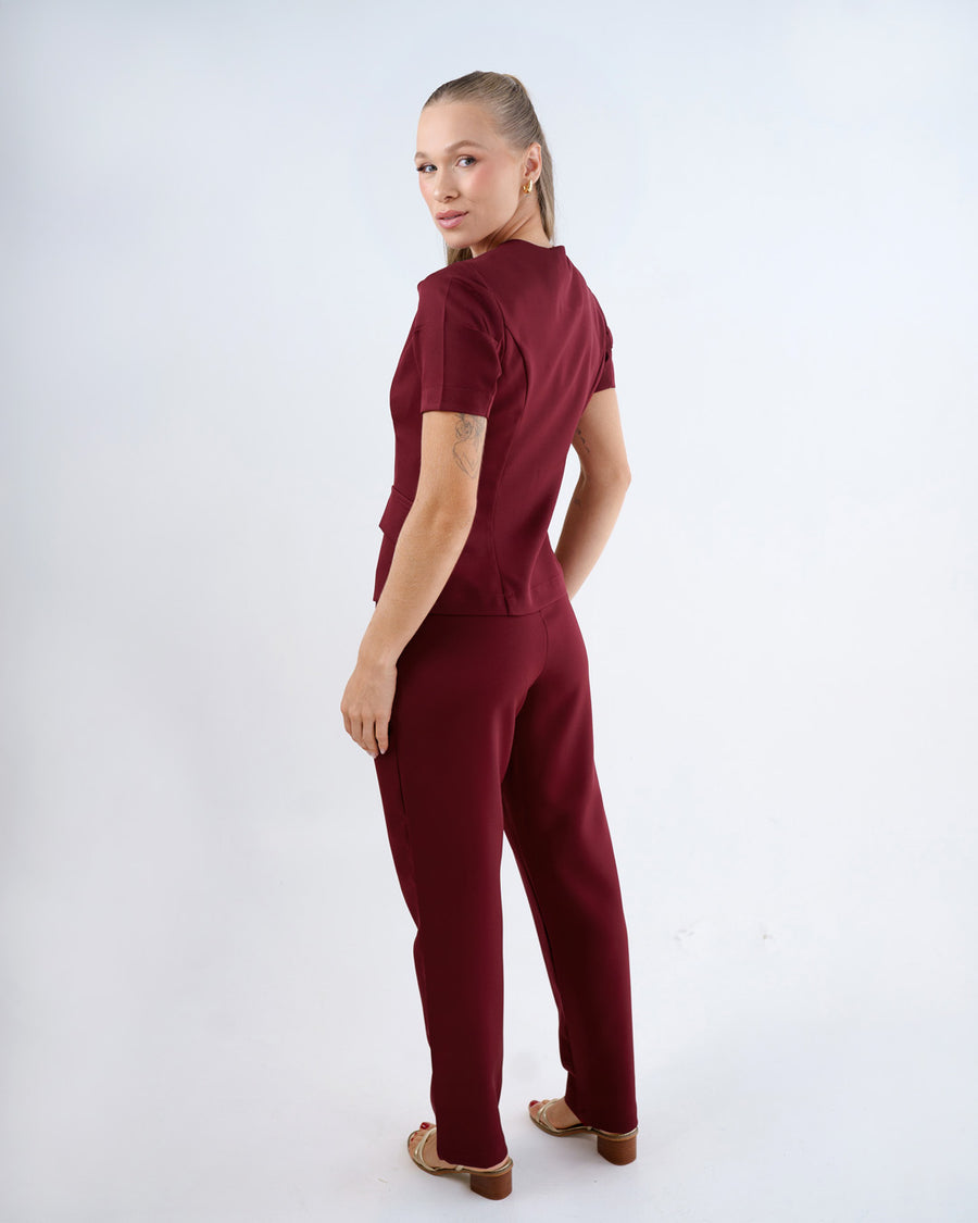 Scrub feminino Classic bordô de costas, mostrando as mangas bufantes e o caimento da blusa e da calça