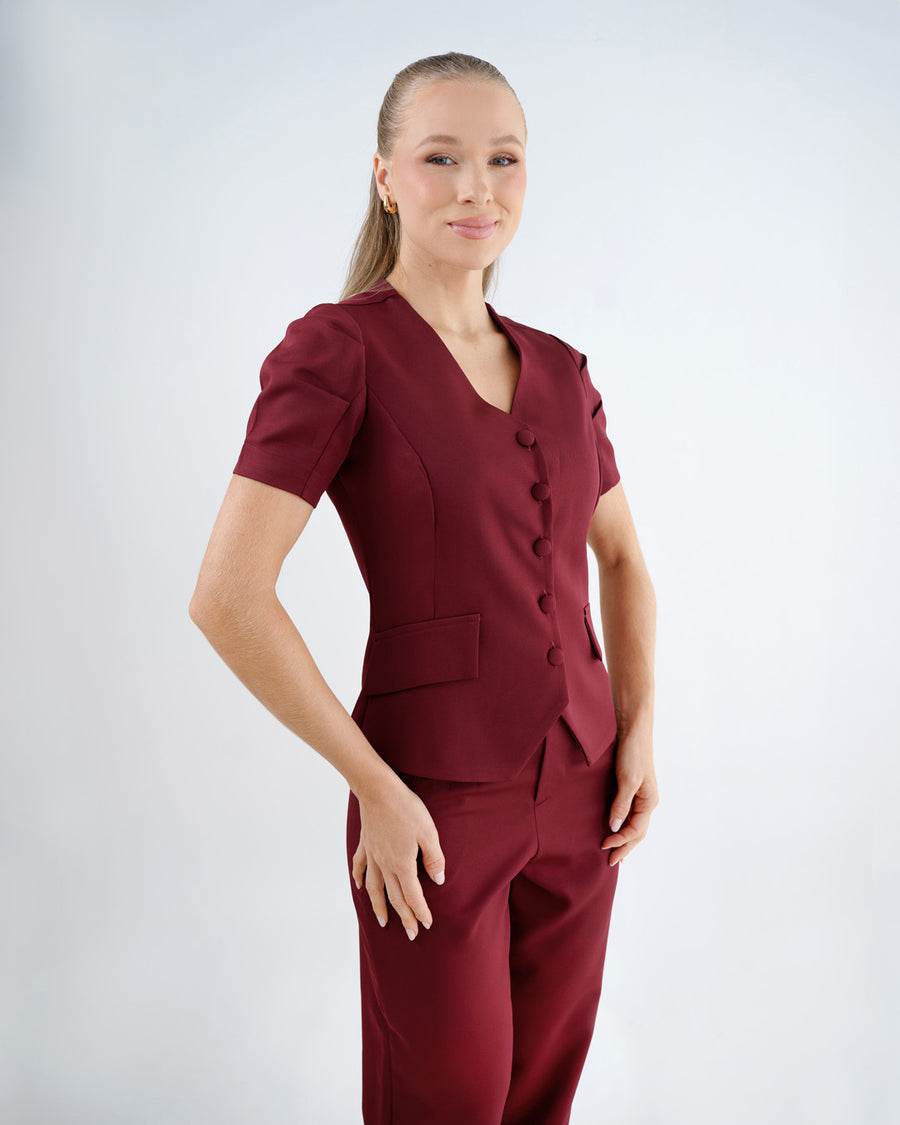 Scrub feminino Classic bordô de lado em meio corpo, mangas bufantes e recortes acinturados da blusa