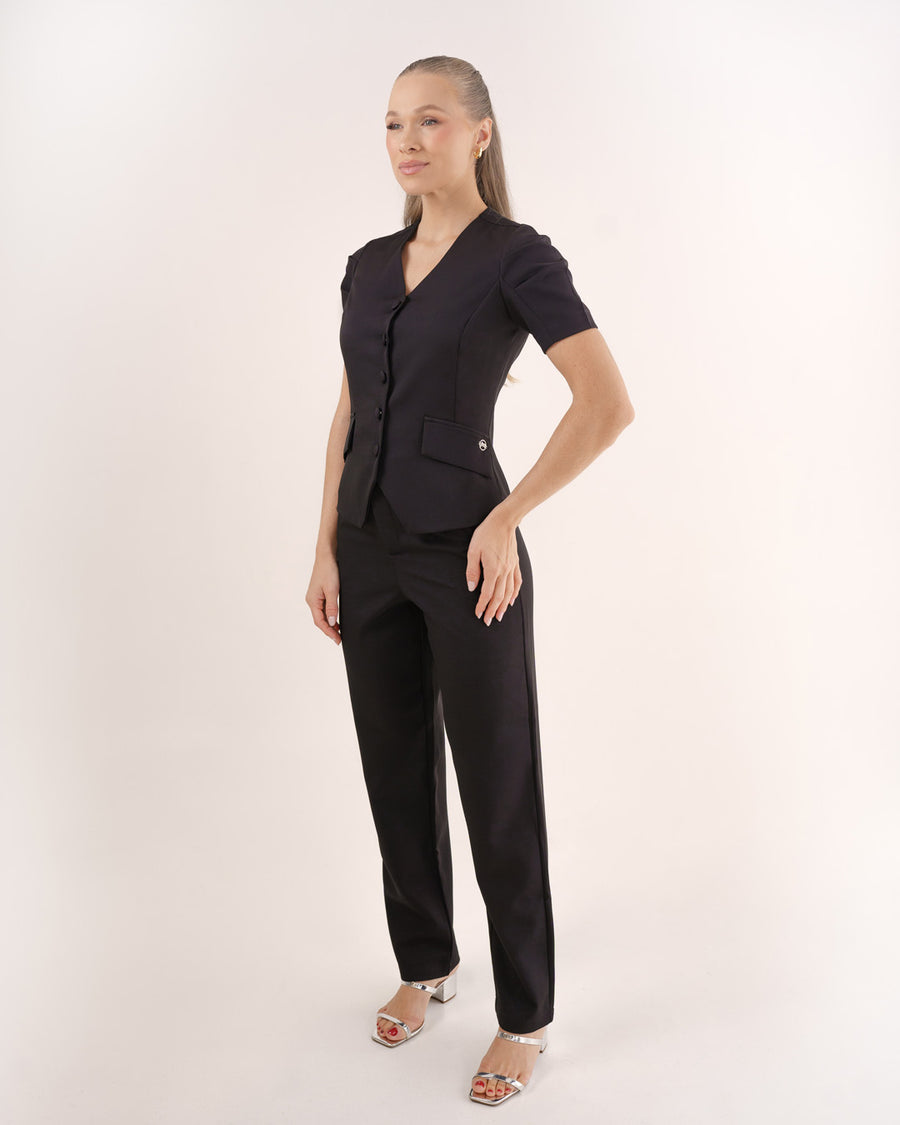 Scrub feminino Classic preto de lado em corpo inteiro, mostrando o caimento da blusa e da calça reta