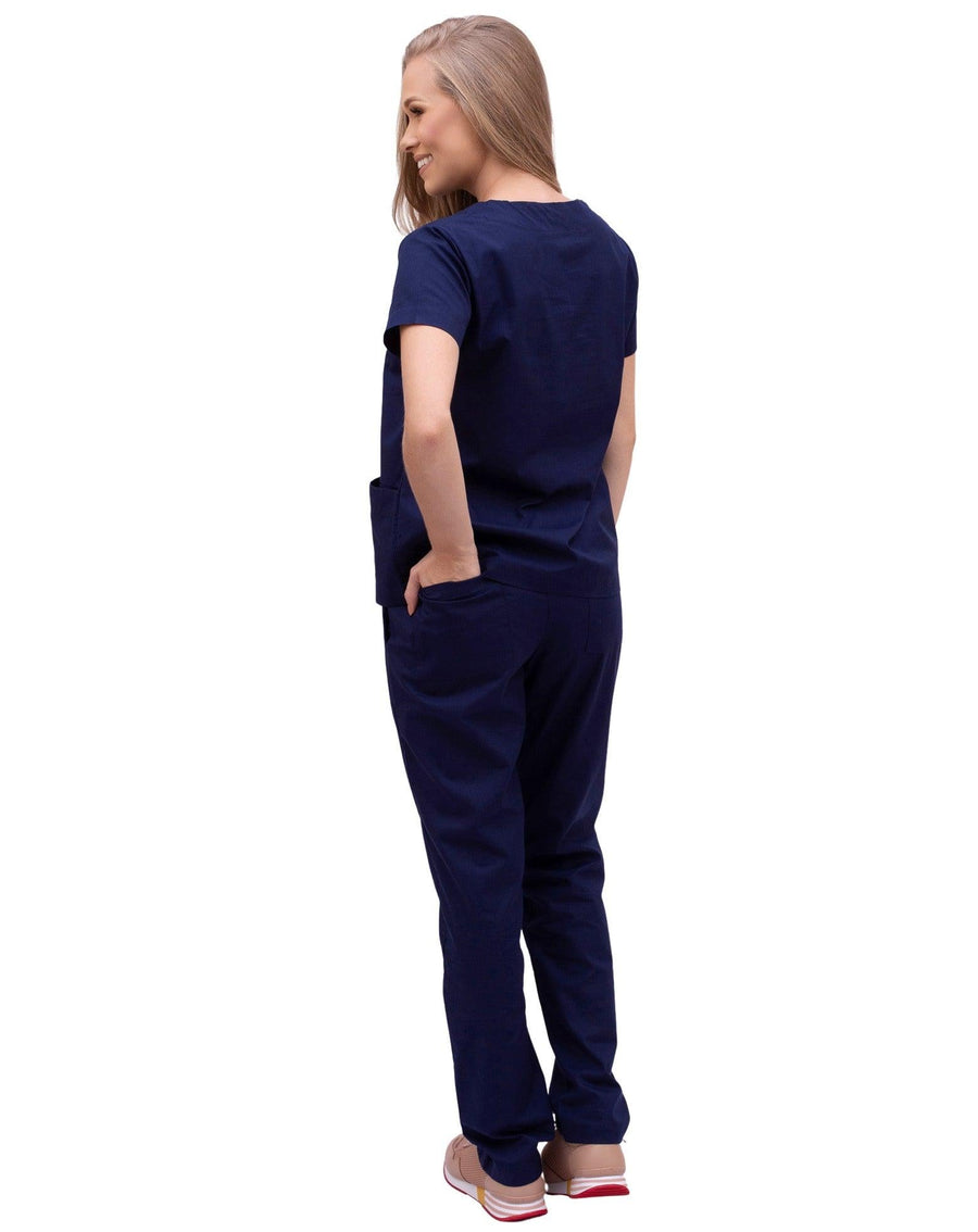Scrub feminino Confort azul marinho de costas, modelo com a mão no bolso da calça de caimento solto