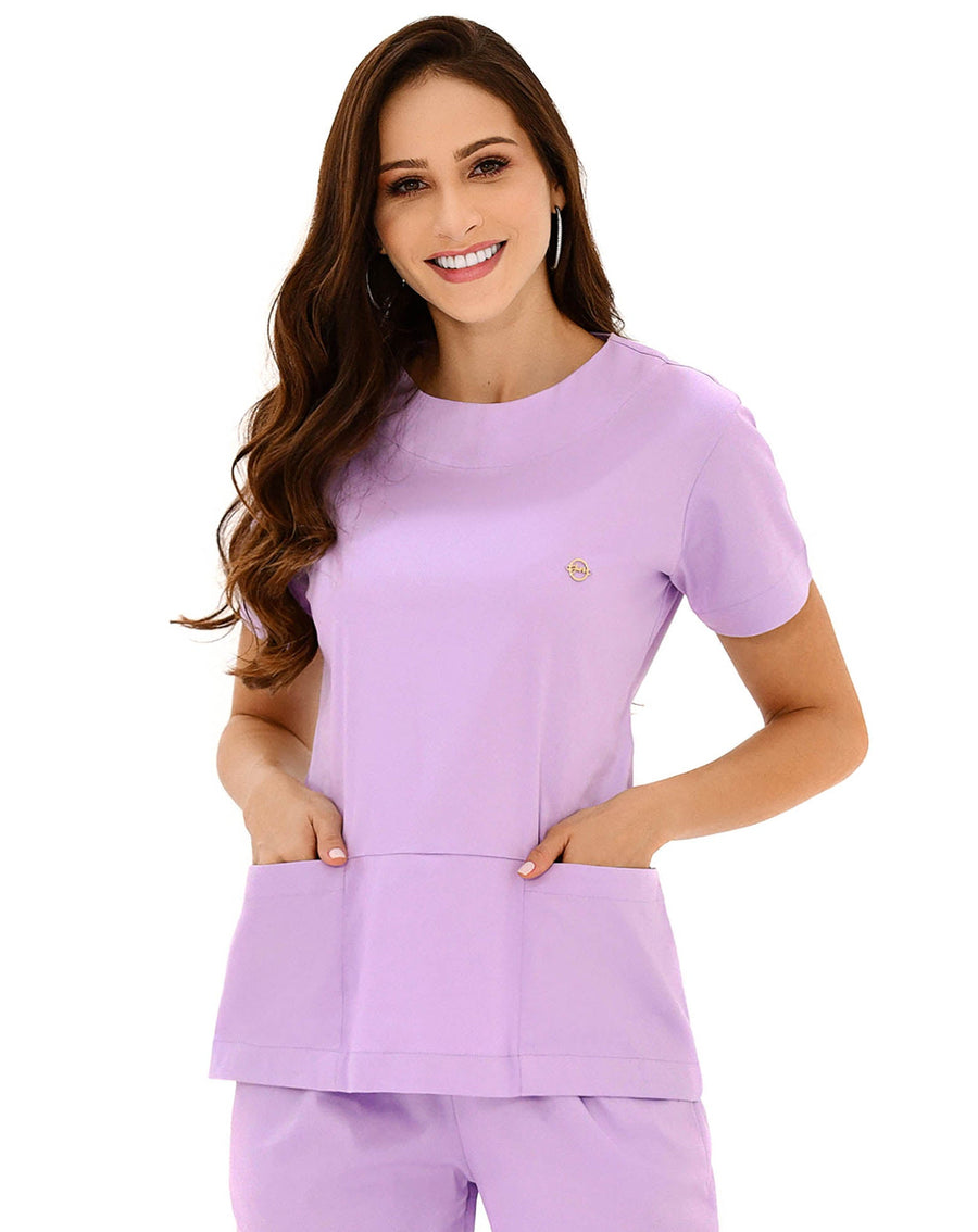 Scrub feminino Confort lilás em meio corpo, detalhe da gola redonda e dos dois bolsos frontais amplos