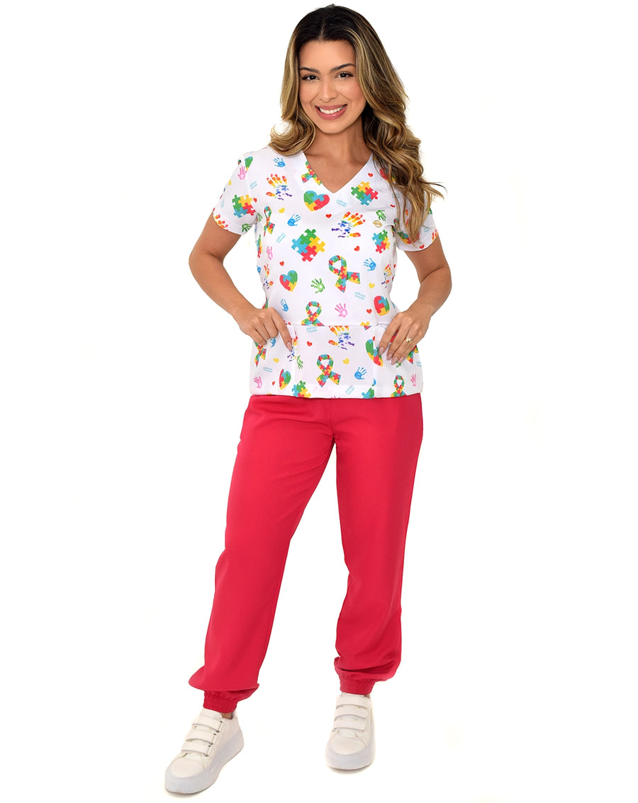Scrub feminino estampado Autismo em Cores de frente, blusa com laços e corações de quebra-cabeça e calça vermelha