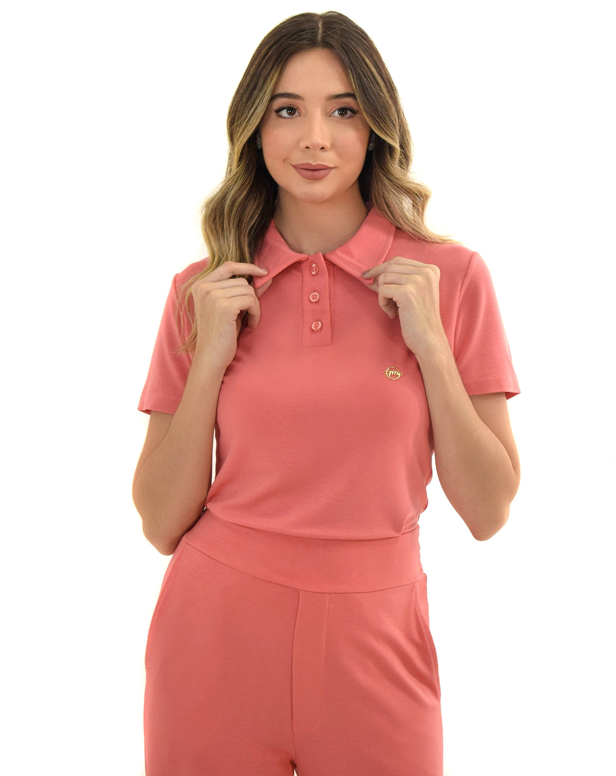 Scrub feminino Ivy moletinho goiaba, detalhe da gola polo com botões, modelo segurando o colarinho da blusa — foto 2