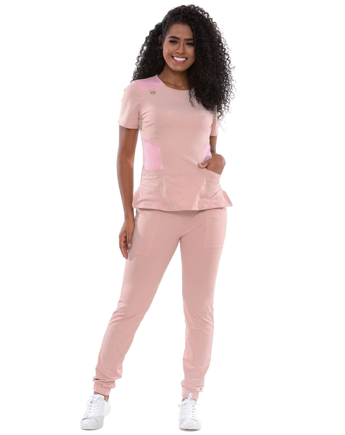Scrub feminino Lily Soft nude com rosa de corpo inteiro, mão no bolso da calça e blusa de gola redonda — foto 3