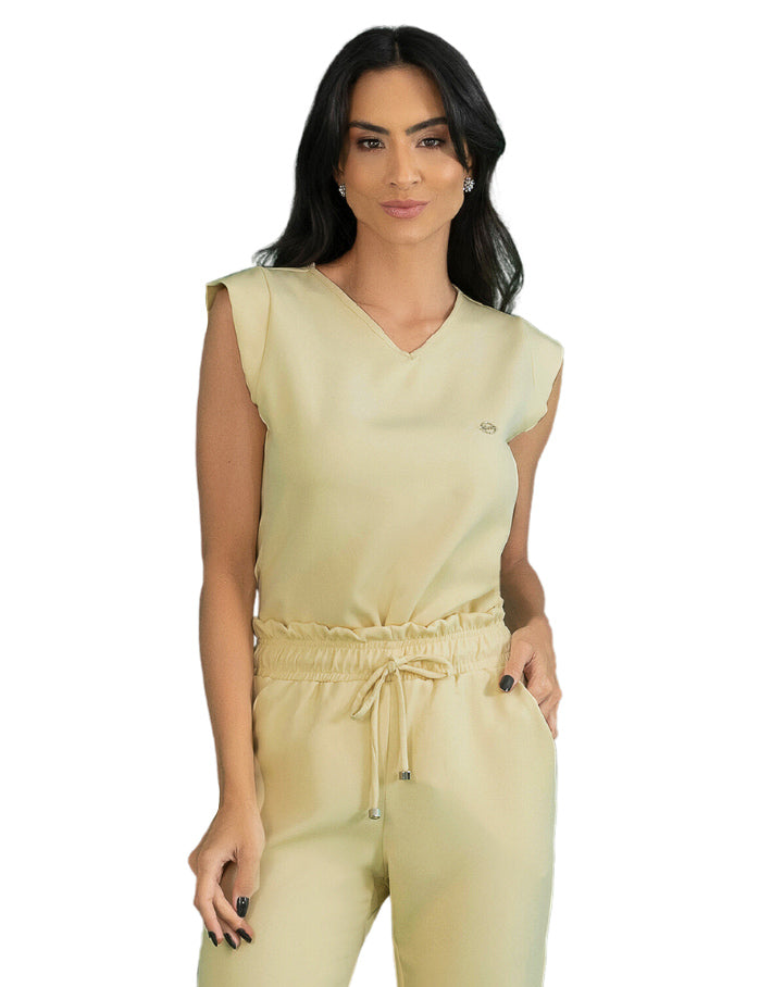 Scrub feminino Luna amarelo creme visto de frente, blusa sem manga com gola V e cintura franzida com cordão