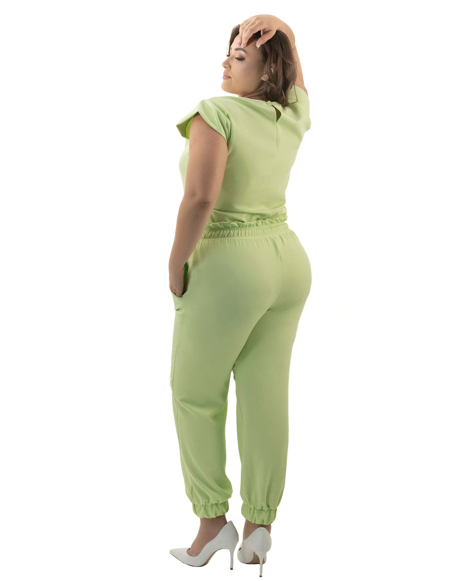 Scrub feminino Luna verde pistache de costas em modelo plus size, calça jogger com punho nos tornozelos