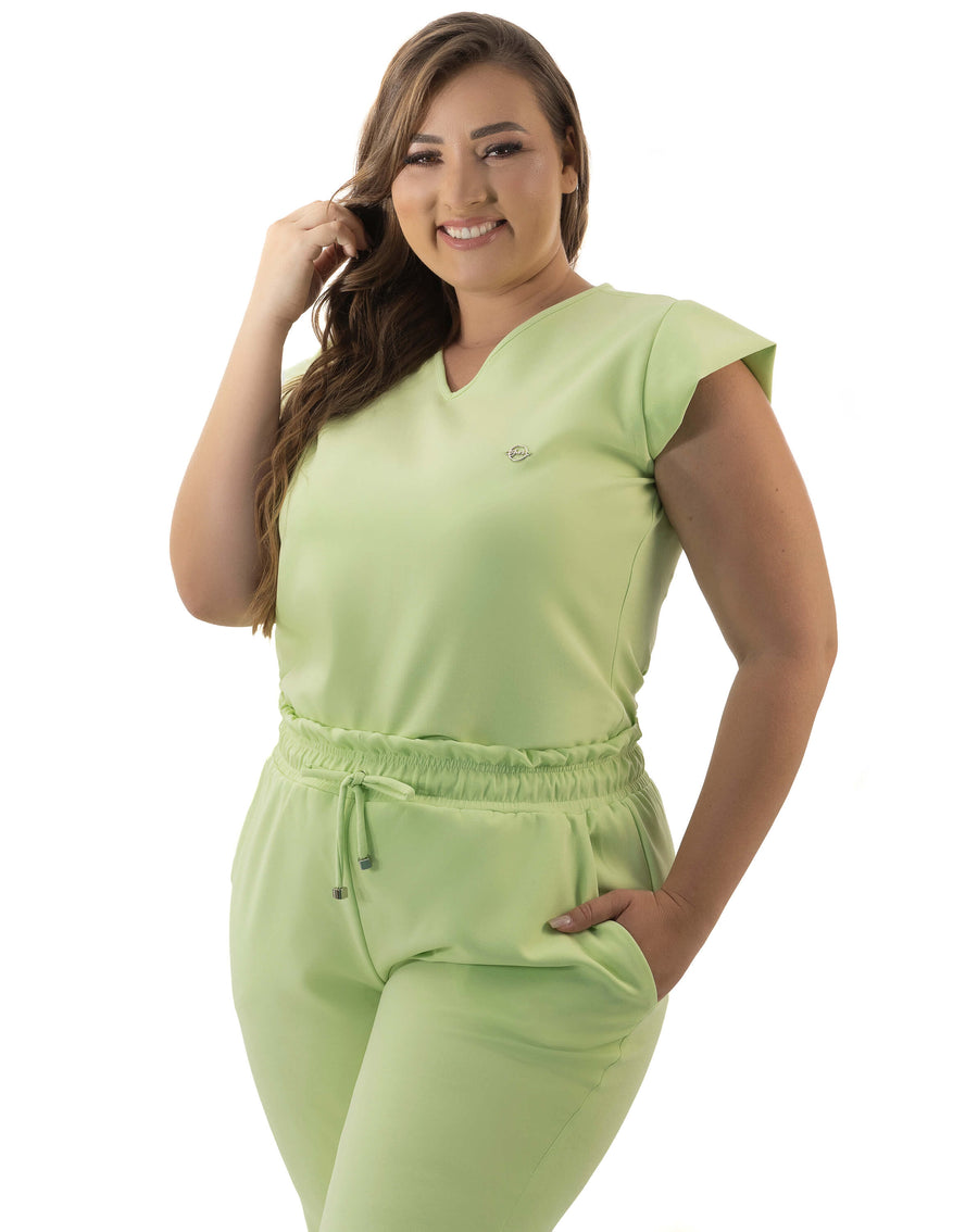 Scrub feminino Luna verde pistache de frente em modelo plus size, blusa gola V e cintura com amarração