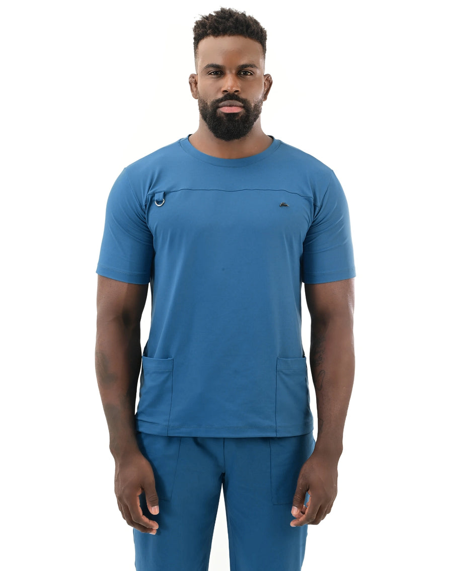 Scrub masculino Neo Soft azul petróleo de frente, detalhe da gola redonda, argola porta crachá e recorte no peito