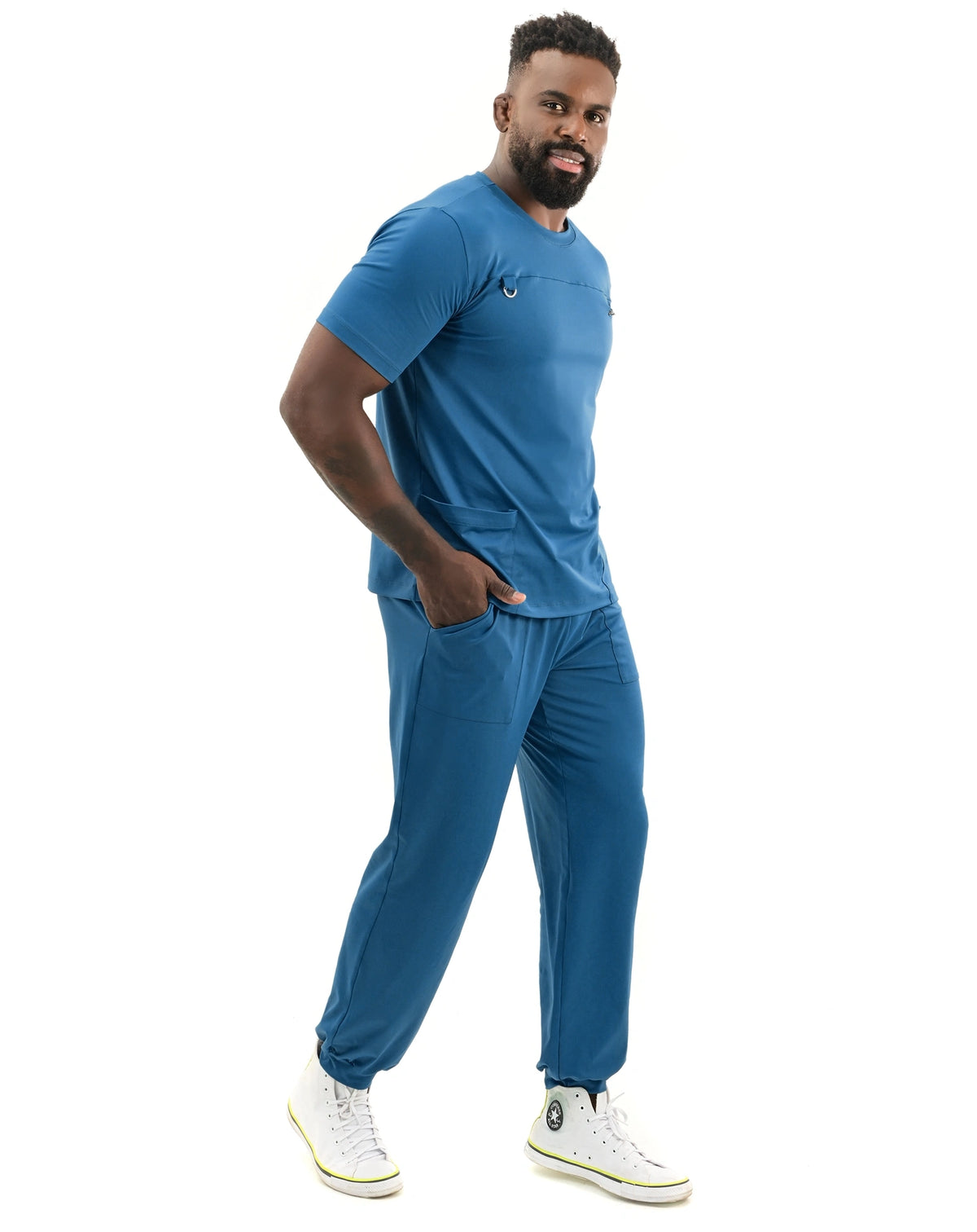 Scrub masculino Neo Soft azul petróleo de lado, modelo com mão no bolso e calça jogger com punho elástico — foto 2