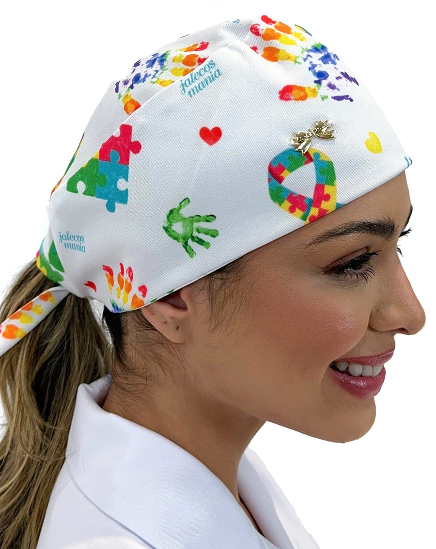Touca bandana feminina autismo em cores em modelo, lateral com estampa de quebra-cabecas, maozinhas e laco colorido