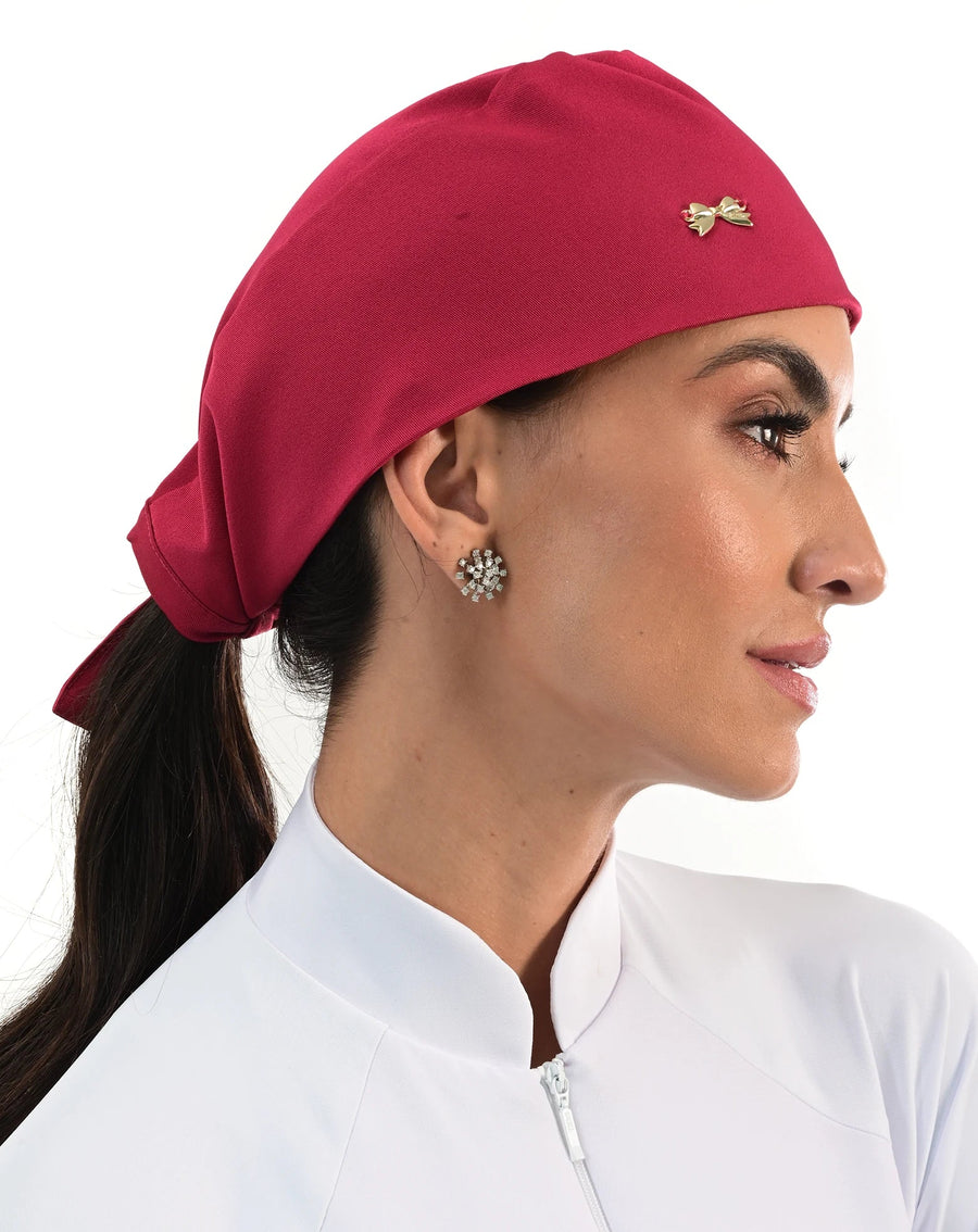 Touca bandana feminina vermelho cereja em modelo, vista lateral com lacinho dourado e pontas amarradas atrás