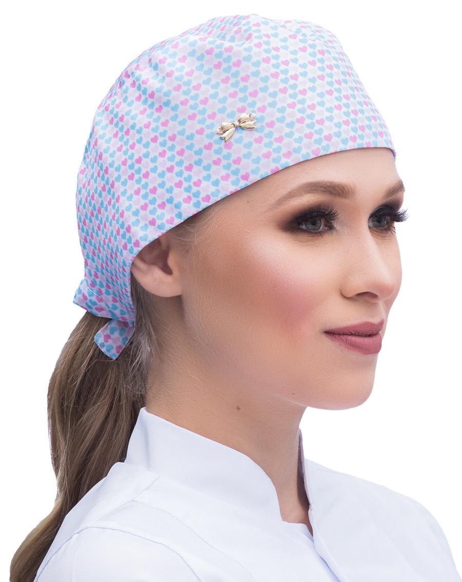 Touca bandana feminina Lovely em modelo, vista lateral, estampa de corações rosa e azuis e lacinho dourado na frente