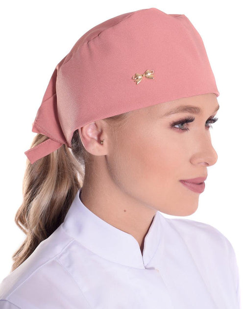 Touca bandana feminina rosé em modelo, vista lateral, com lacinho dourado aplicado e amarração atrás