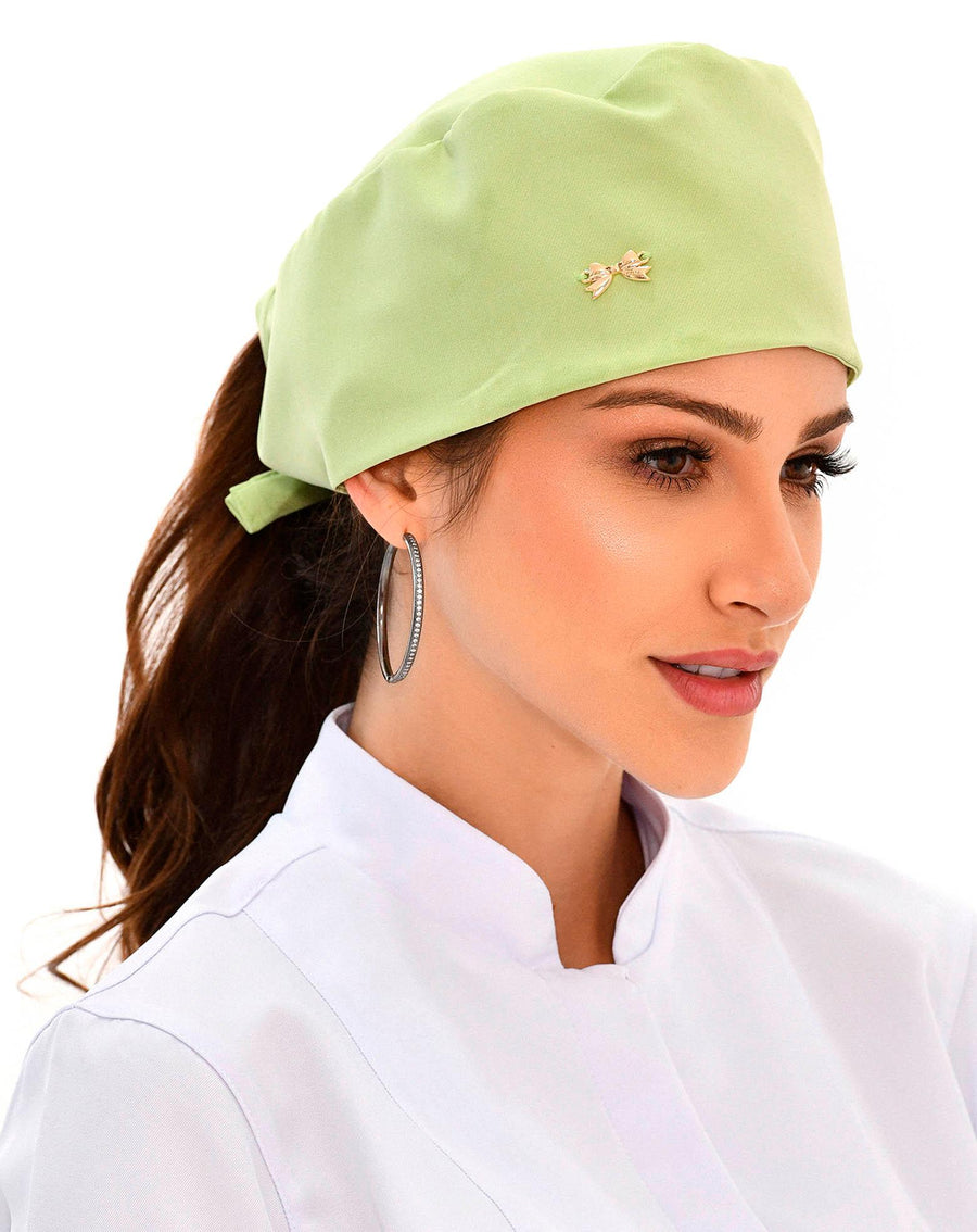 Touca bandana feminina verde pistache em modelo, vista lateral, com lacinho aplicado e pontas amarradas na nuca