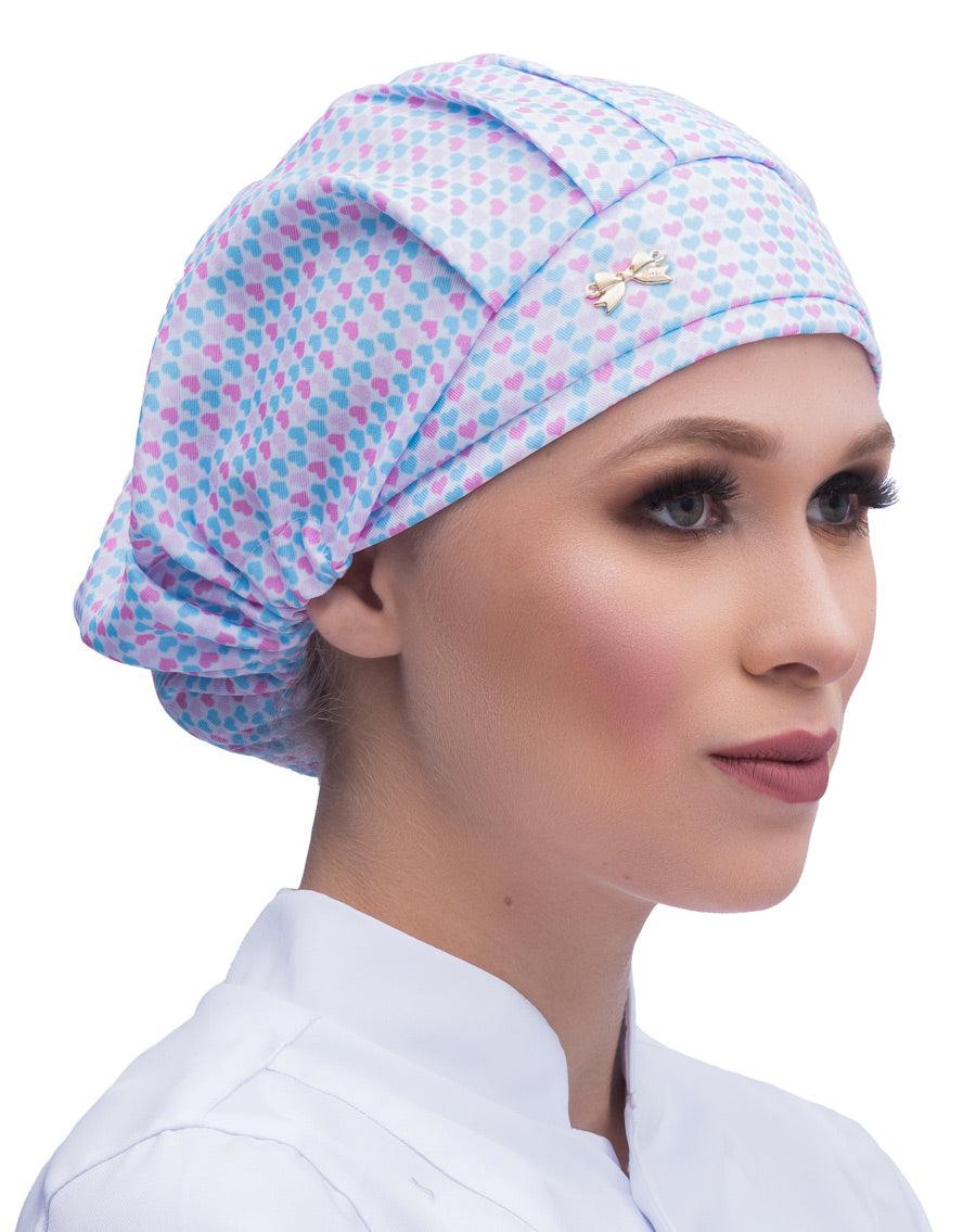 Touca elástico feminina Lovely em modelo, estampa de coraçõezinhos azuis e rosa com lacinho dourado na frente