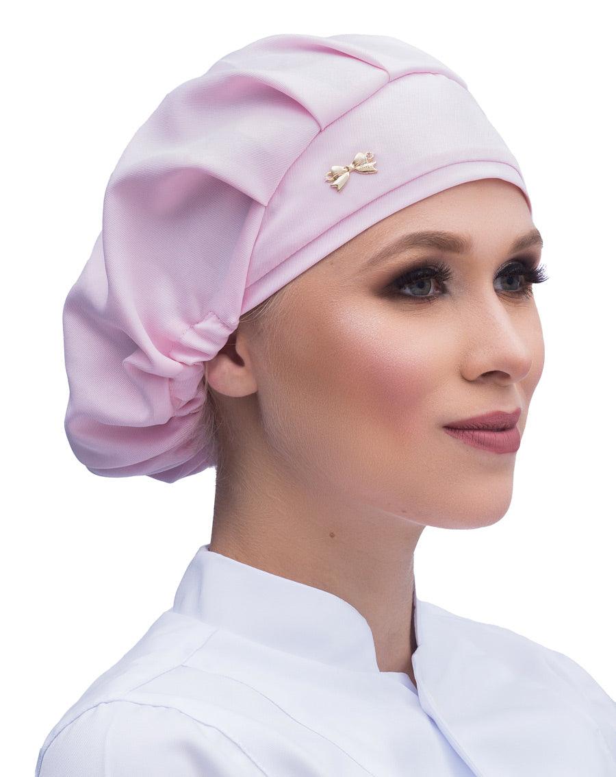 Touca elástico feminina rosa claro em modelo, vista lateral, tecido liso com pregas e lacinho dourado na frente