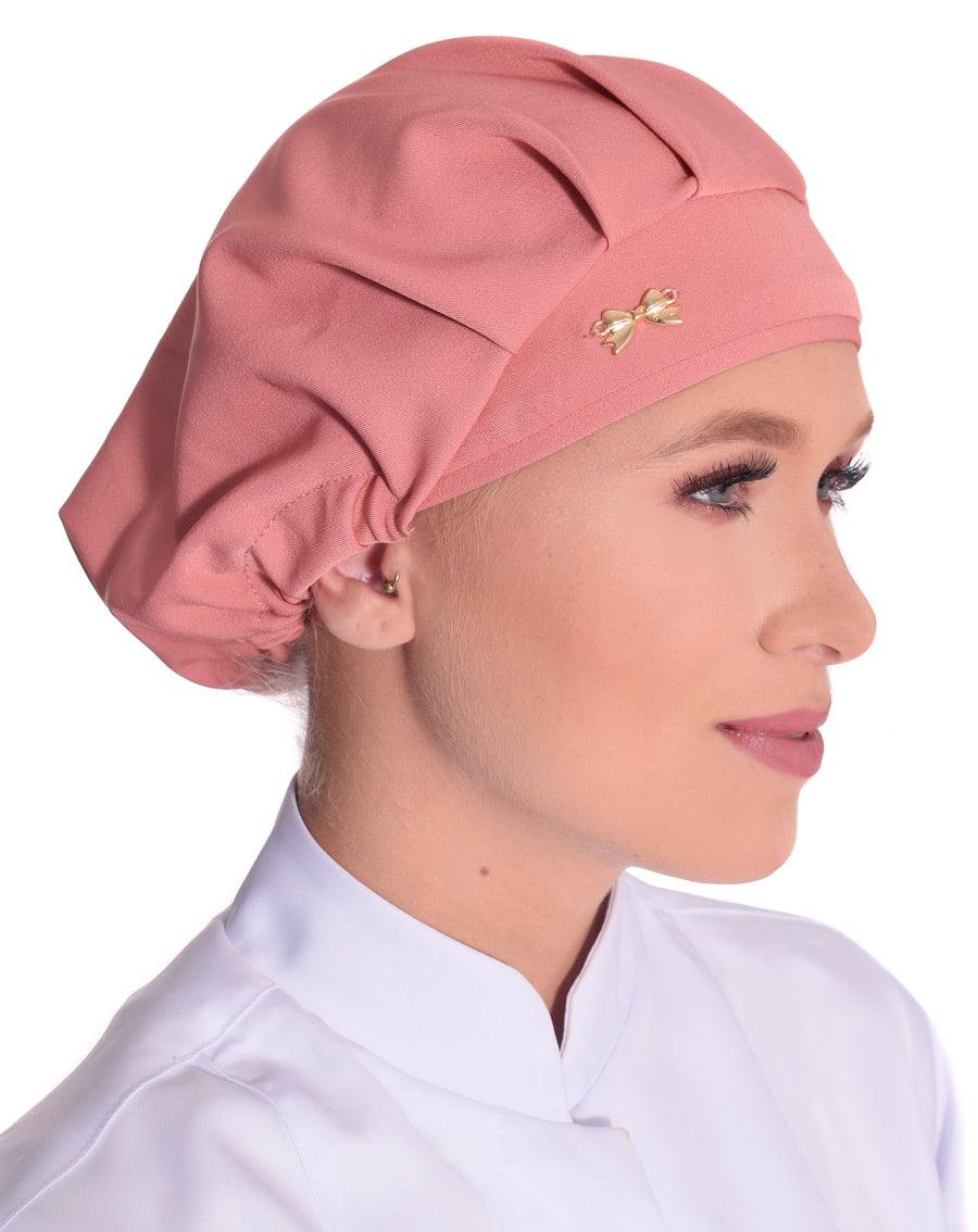 Touca elástico feminina rosé em modelo, vista lateral, tecido liso com pregas e lacinho dourado na frente
