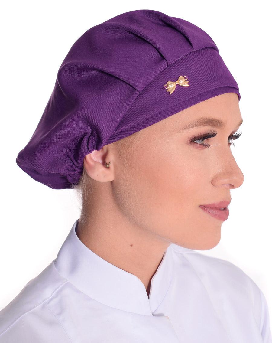 Touca elástico feminina violeta em modelo, vista lateral, com pregas frontais e lacinho dourado aplicado
