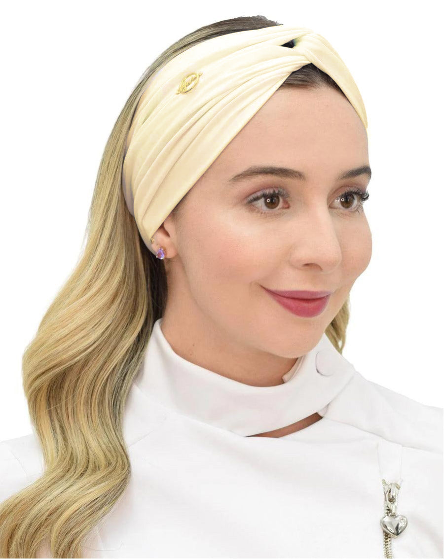 Turbante feminino amarelo creme em modelo de meio perfil, tecido acetinado cruzado na frente e cabelo solto