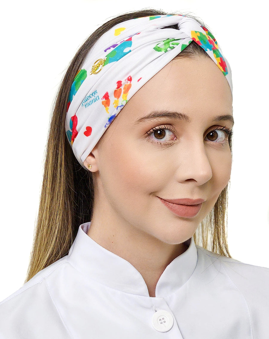 Turbante feminino autismo em cores em modelo, vista frontal, estampa de quebra-cabeça colorido e coração vermelho