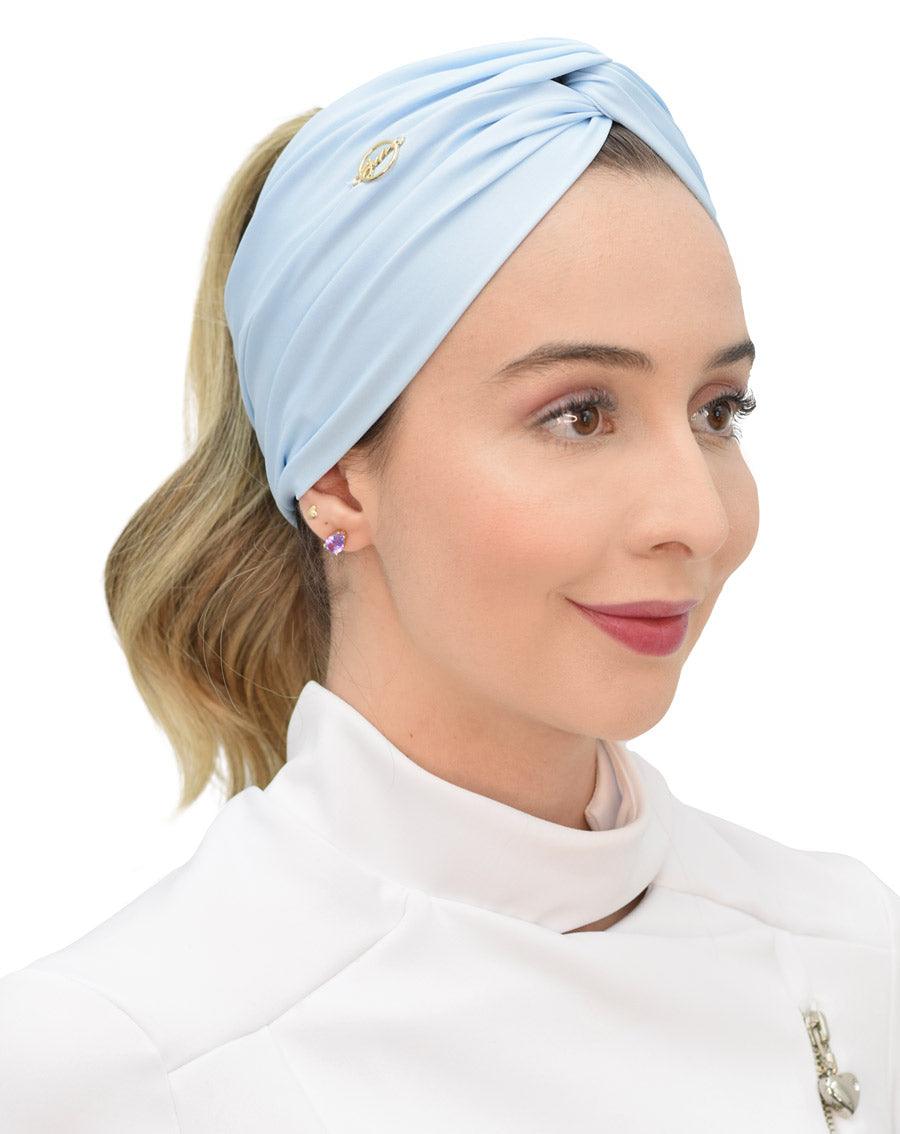 Turbante feminino azul claro em modelo, vista lateral, tecido drapeado cobrindo a cabeça e cabelo preso