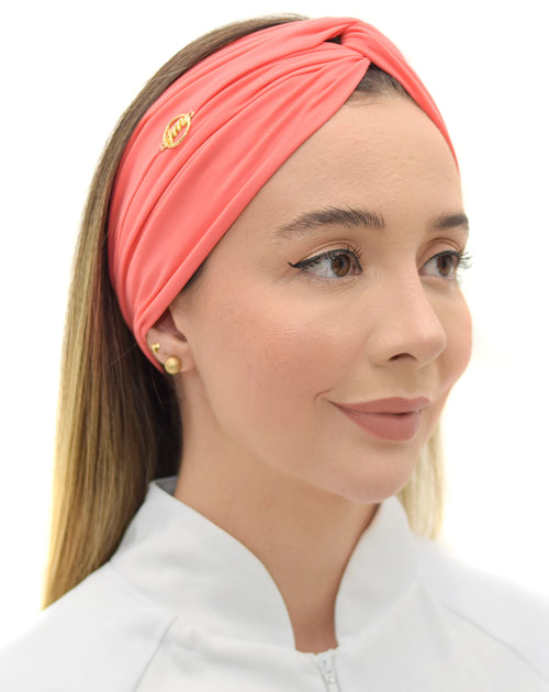 Turbante feminino goiaba em modelo, vista frontal, tecido coral franzido cruzado na frente e cabelo solto