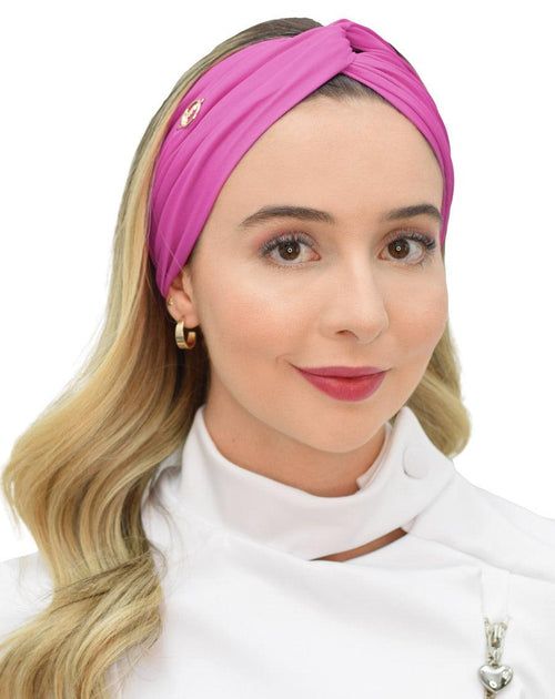 Turbante feminino rosa fúcsia em modelo, vista frontal, nó torcido no topo e tecido franzido cobrindo a testa