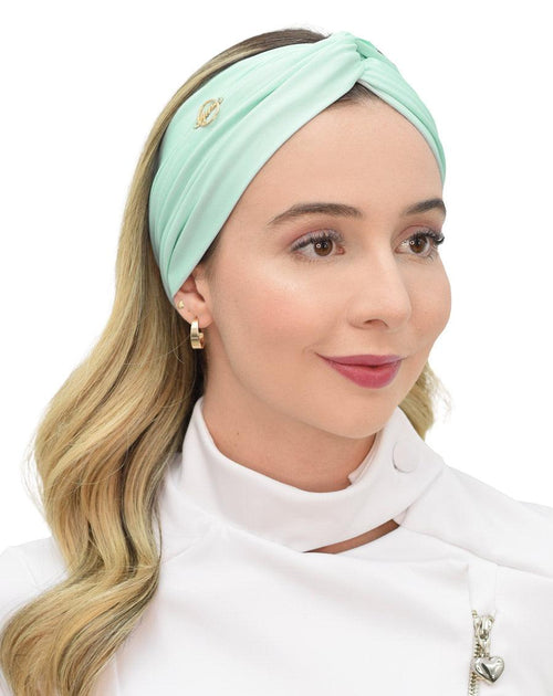 Modelo de cabelo solto com turbante feminino verde água, vista frontal do trançado torcido e do pin dourado