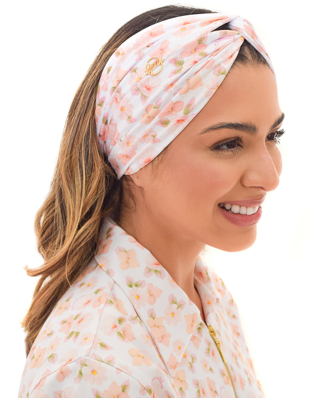 Turbante feminino gardênia em modelo sorrindo, vista lateral, estampa floral rosa combinando com o jaleco